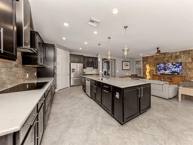 kitchen featuring pendant lighting, sink, ceiling fan, an island with sink, and appliances with stainless steel finishes