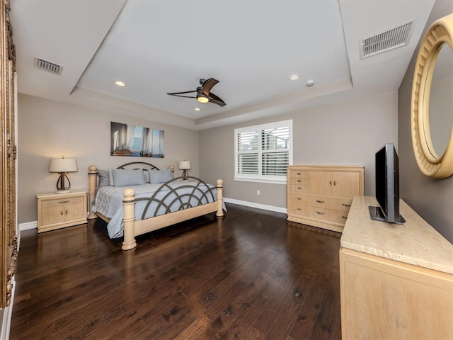 bedroom with dark hardwood / wood-style floors, a raised ceiling, and ceiling fan