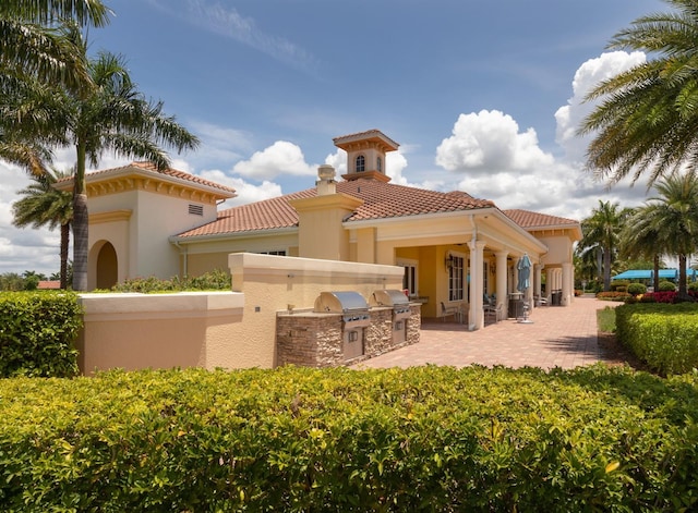 rear view of house with a patio area and exterior kitchen