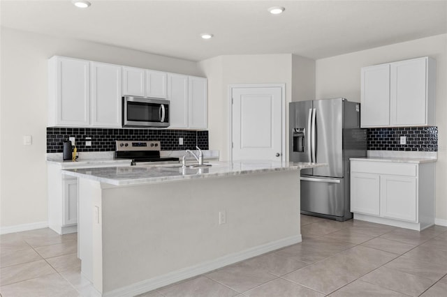 kitchen featuring white cabinets, stainless steel appliances, and a kitchen island with sink