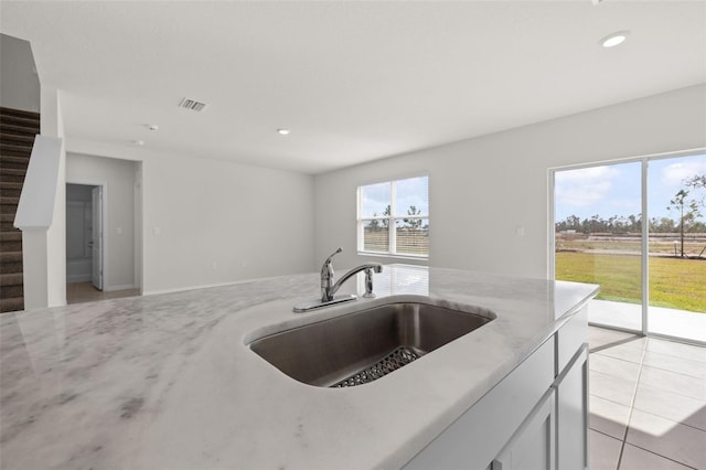 kitchen featuring white cabinetry, sink, and light tile patterned floors