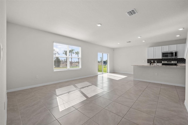 unfurnished living room featuring light tile patterned floors