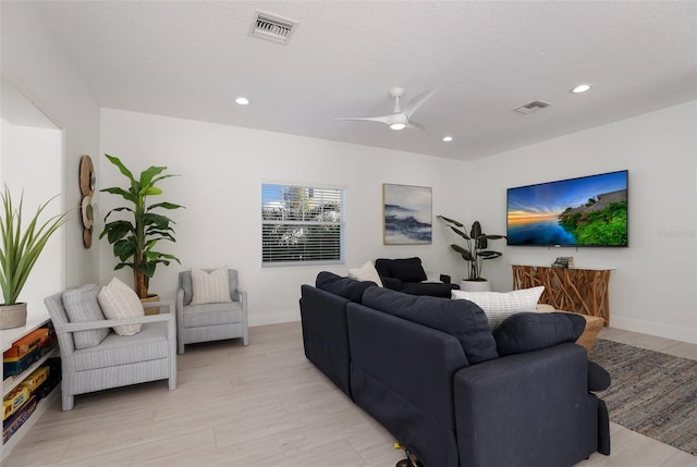 living room with ceiling fan and a textured ceiling