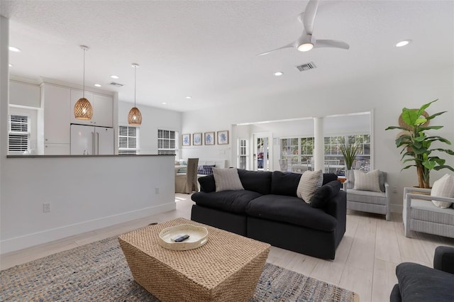 living room featuring ceiling fan and light hardwood / wood-style flooring