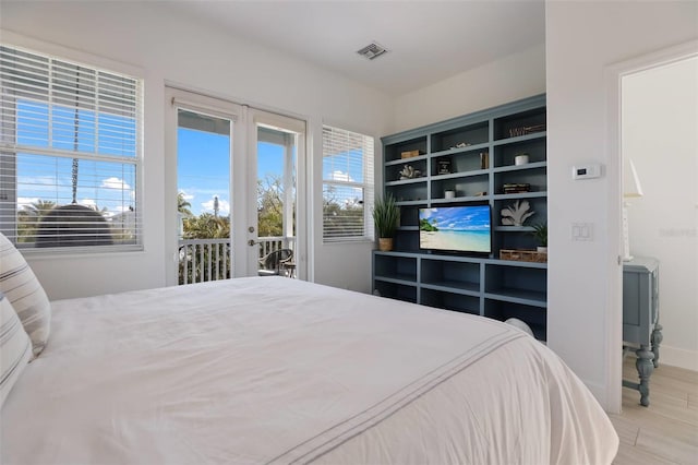 bedroom with access to exterior, french doors, and light wood-type flooring