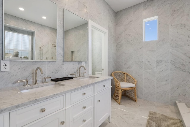 bathroom with vanity and tile walls