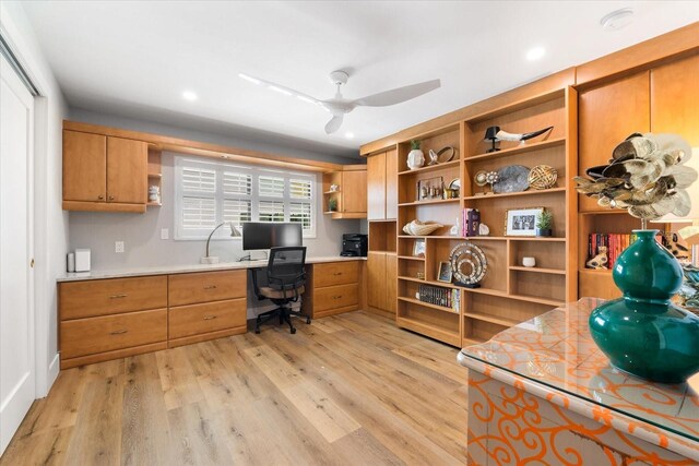 office featuring ceiling fan, built in desk, and light wood-type flooring