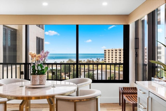 sunroom featuring a water view