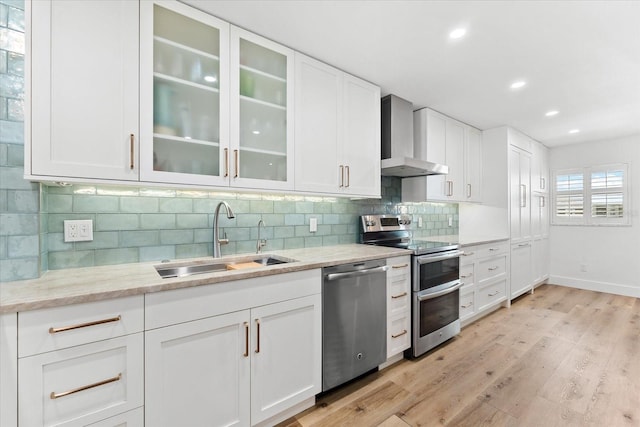 kitchen featuring white cabinetry, sink, wall chimney exhaust hood, tasteful backsplash, and appliances with stainless steel finishes