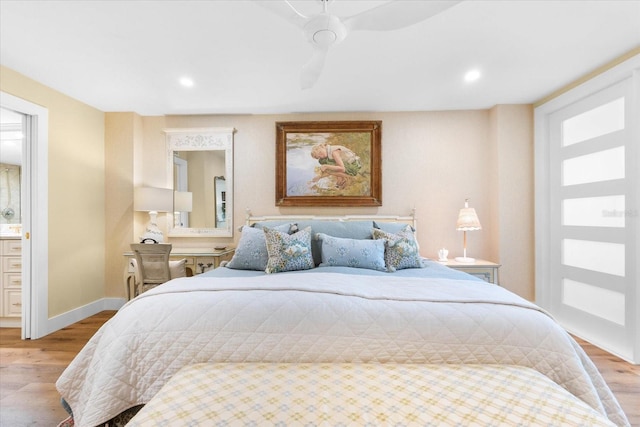 bedroom with ceiling fan, connected bathroom, and light hardwood / wood-style flooring