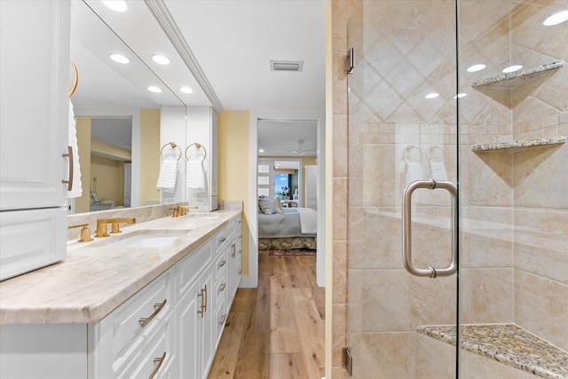 bathroom with wood-type flooring, vanity, and a shower with shower door