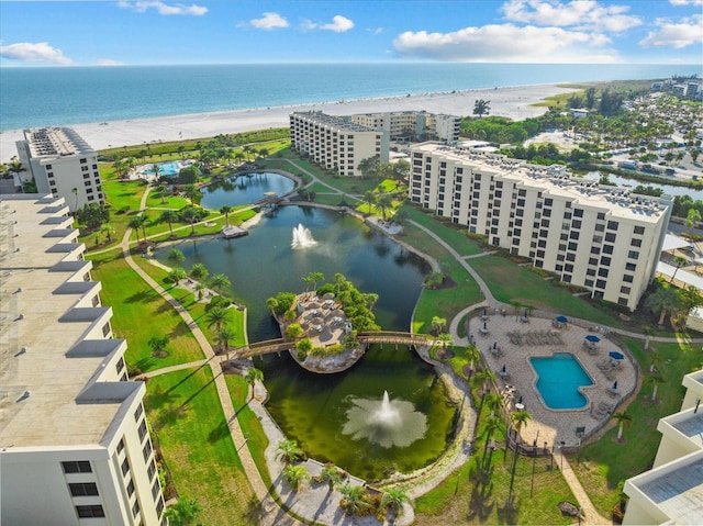 birds eye view of property featuring a water view and a beach view