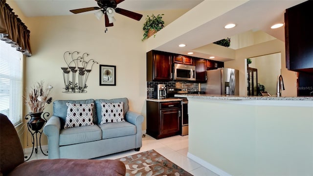 tiled living room featuring ceiling fan and sink