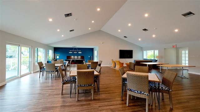 dining room with hardwood / wood-style flooring, high vaulted ceiling, and a wealth of natural light