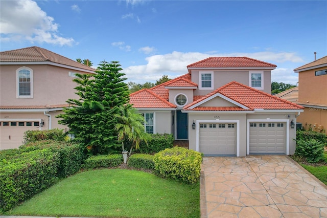 mediterranean / spanish house featuring a garage, a tiled roof, concrete driveway, and stucco siding