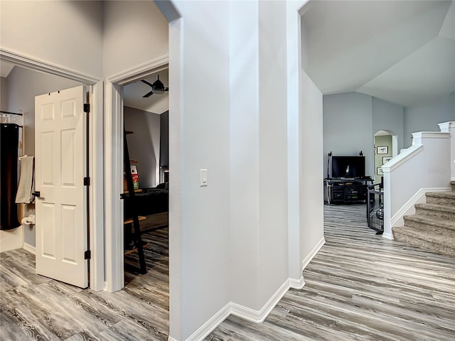 corridor featuring vaulted ceiling and light hardwood / wood-style flooring