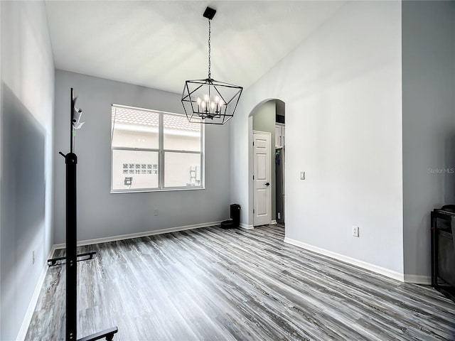 unfurnished dining area featuring hardwood / wood-style floors and a notable chandelier