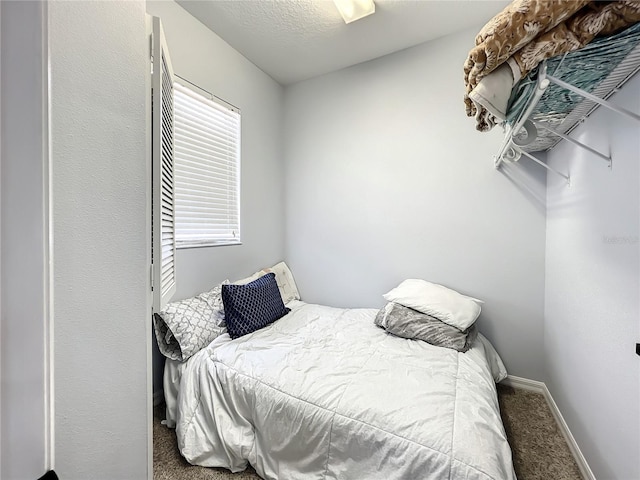 bedroom featuring carpet and a textured ceiling