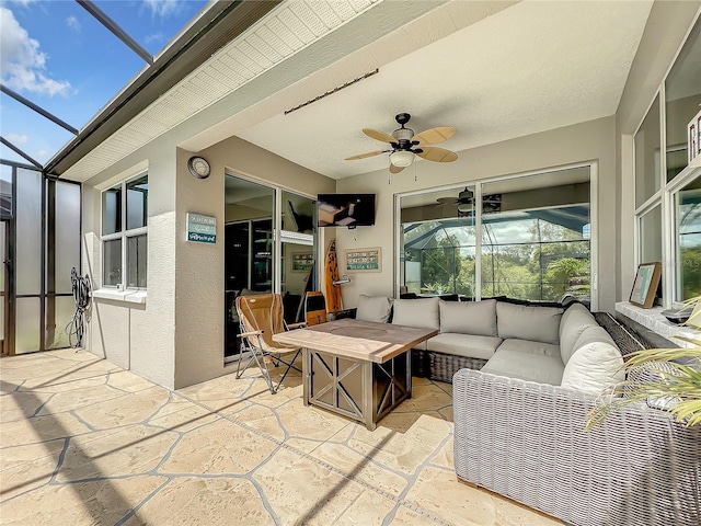 view of patio with glass enclosure, ceiling fan, and an outdoor hangout area