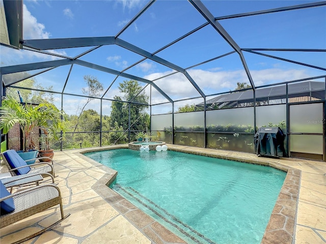 view of pool with an in ground hot tub, glass enclosure, and a patio area