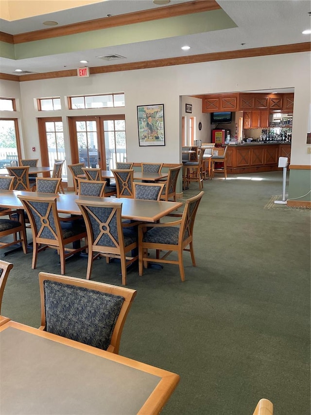 dining room featuring carpet floors, crown molding, and a tray ceiling