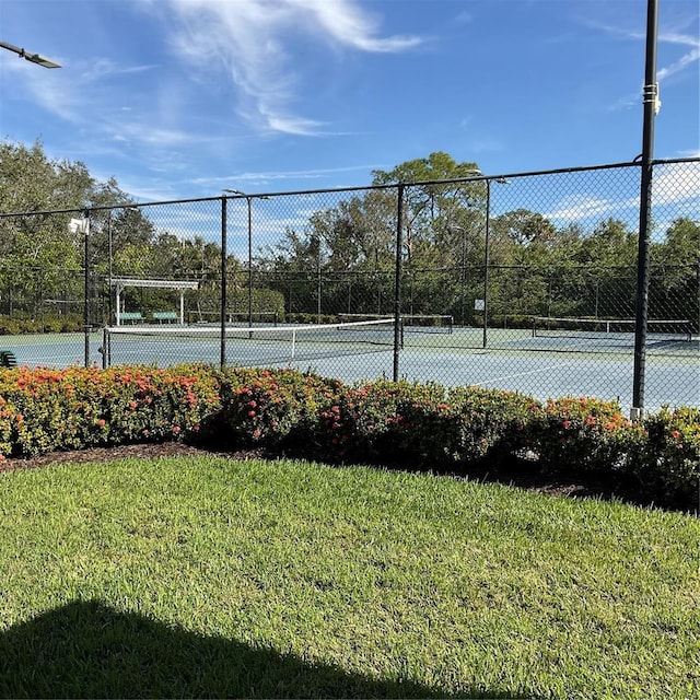 view of sport court featuring a yard and fence