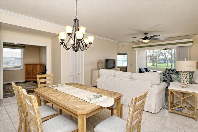 tiled dining space featuring a textured ceiling, crown molding, and ceiling fan with notable chandelier