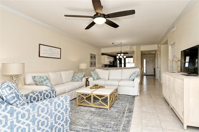 living room featuring light tile patterned floors, ceiling fan with notable chandelier, and ornamental molding