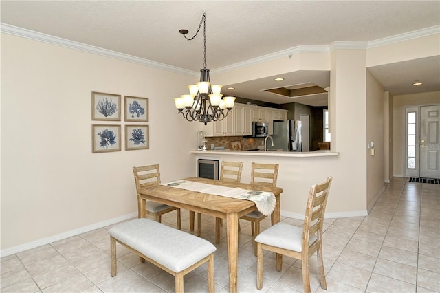 tiled dining room with a notable chandelier, ornamental molding, and sink