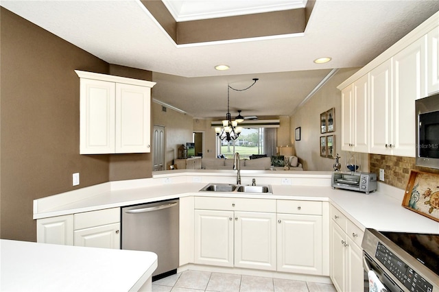 kitchen featuring kitchen peninsula, stainless steel appliances, sink, light tile patterned floors, and a chandelier