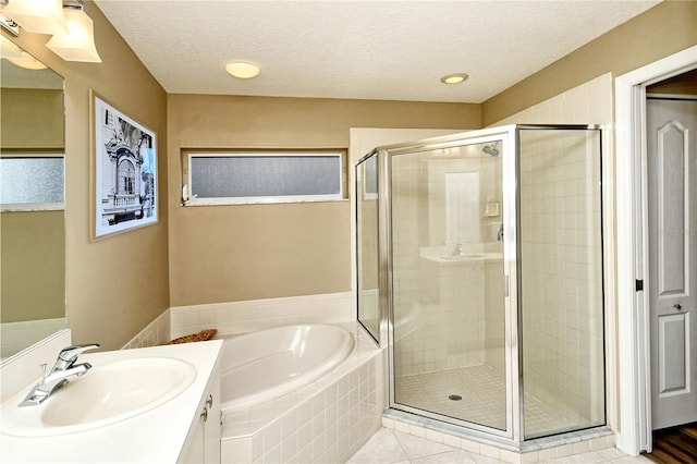 bathroom featuring a textured ceiling, vanity, separate shower and tub, and tile patterned floors