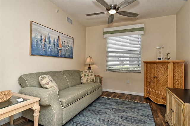 living room featuring ceiling fan and dark wood-type flooring