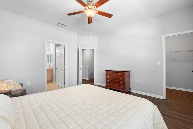 bedroom with ensuite bath, ceiling fan, wood-type flooring, a walk in closet, and a closet