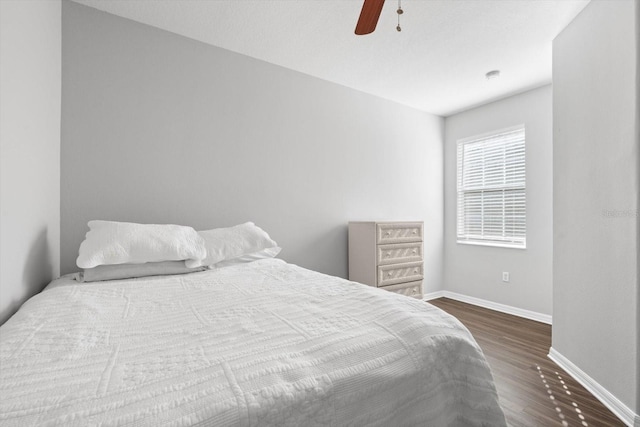 bedroom with dark hardwood / wood-style floors and ceiling fan