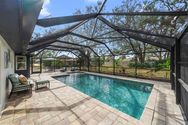 view of swimming pool with a patio area and a lanai