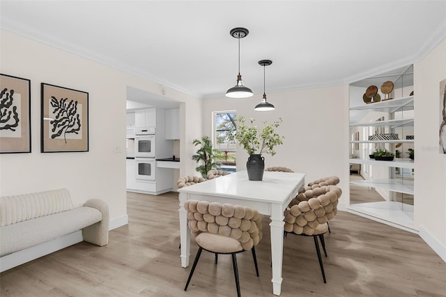 dining area featuring crown molding and light wood-type flooring