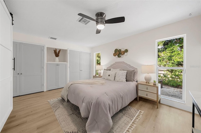 bedroom featuring multiple windows, light hardwood / wood-style flooring, and ceiling fan