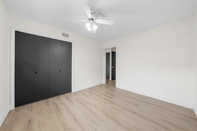 unfurnished bedroom featuring ceiling fan, light wood-type flooring, and a closet