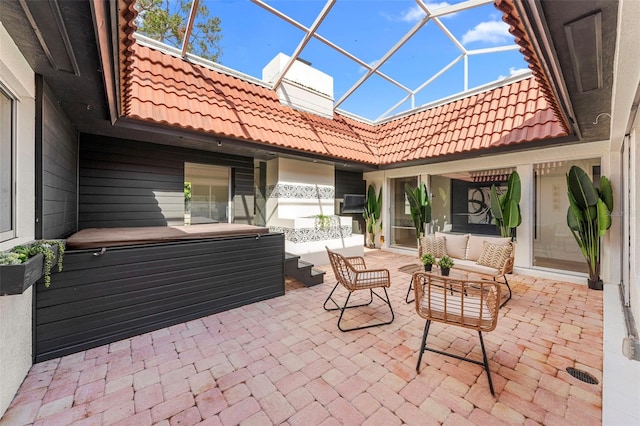 view of patio with an outdoor living space and glass enclosure