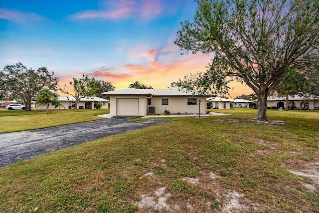 single story home with a garage and a yard