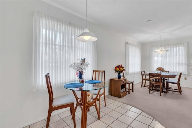 dining space featuring an inviting chandelier and light colored carpet