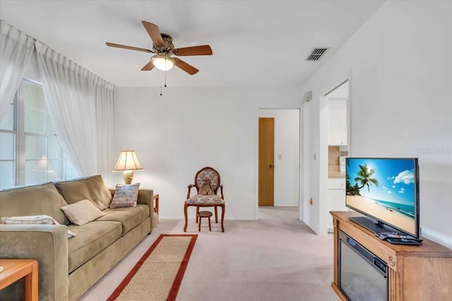 carpeted living room with ceiling fan