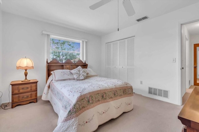 bedroom with light carpet, ceiling fan, and a closet