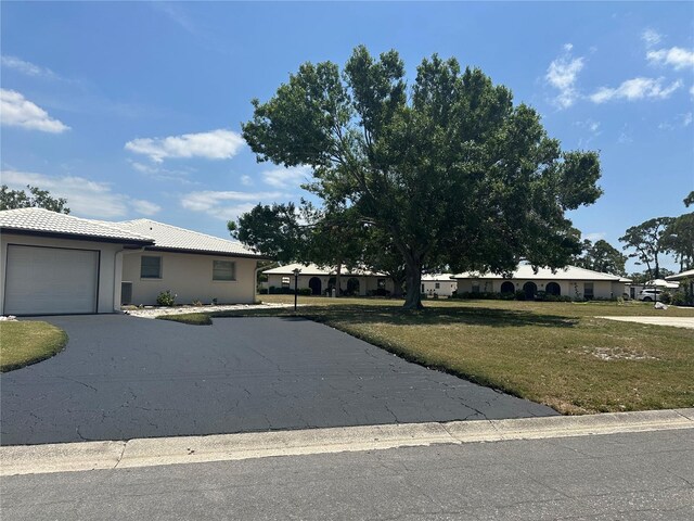 430 Botticelli Dr Unit 430, Nokomis, FL 34275 - single story home featuring a tile roof, a front lawn, aphalt driveway, an attached garage, and stucco siding