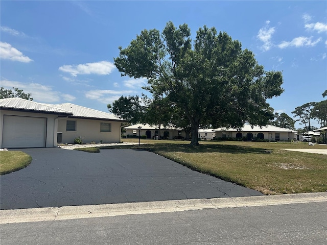430 Botticelli Dr Unit 430, Nokomis, FL 34275 - ranch-style house featuring an attached garage, a tile roof, a front lawn, asphalt driveway, and stucco siding
