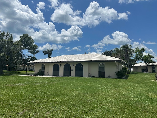 430 Botticelli Dr Unit 430, Nokomis, FL 34275 - back of property featuring a lawn, stucco siding, and a tile roof