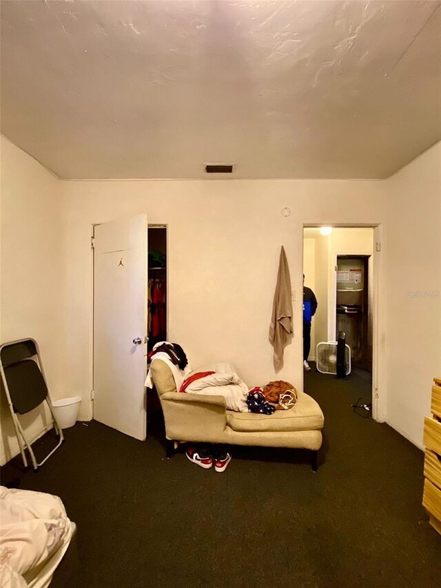 bedroom with dark colored carpet and a closet