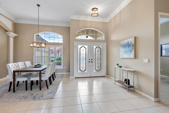 foyer entrance with ornamental molding, an inviting chandelier, and light tile patterned floors