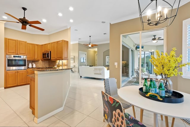 kitchen with pendant lighting, stainless steel appliances, backsplash, stone countertops, and light tile patterned flooring