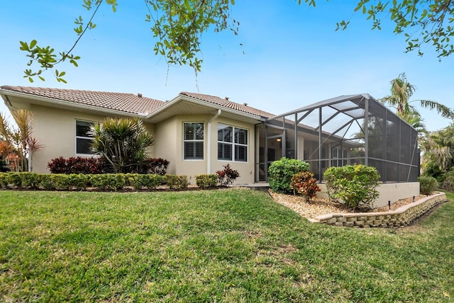 rear view of property featuring a lawn and a lanai